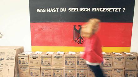 Kunst in Kisten. Und Serge Kliavings schwarz-rot-goldene Arbeit „Was hast du seelisch eingesetzt?“ im Bethanien.