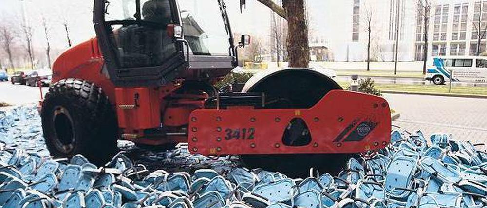 Plattmachen! Eine Dampfwalze zerstört Plagiate eines Einkaufskorbes. Das Geschäft mit gefälschten Markenprodukten floriert. Foto: p-a/dpa