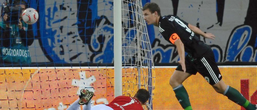 Er brachte den VfL in Führung: Edin Dzeko jubelt über das 1:0. Frank Rost liegt geschlagen am Boden.