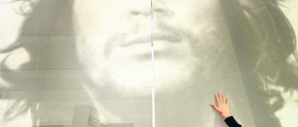 Streicheleinheiten für den Star. Eine Buchmessen-Mitarbeiterin sorgt dafür, dass Che Guevara das Treiben im Argentinien-Pavillon faltenfrei beobachten kann. Foto: dpa/Boris Roessler