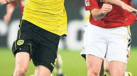 Den entscheidenden Schritt schneller. Nuri Sahin, hier links im Laufduell mit Kölns Fabrice Ehret, schoss die Dortmunder kurz vor Schluss zum Sieg. Foto: AFP