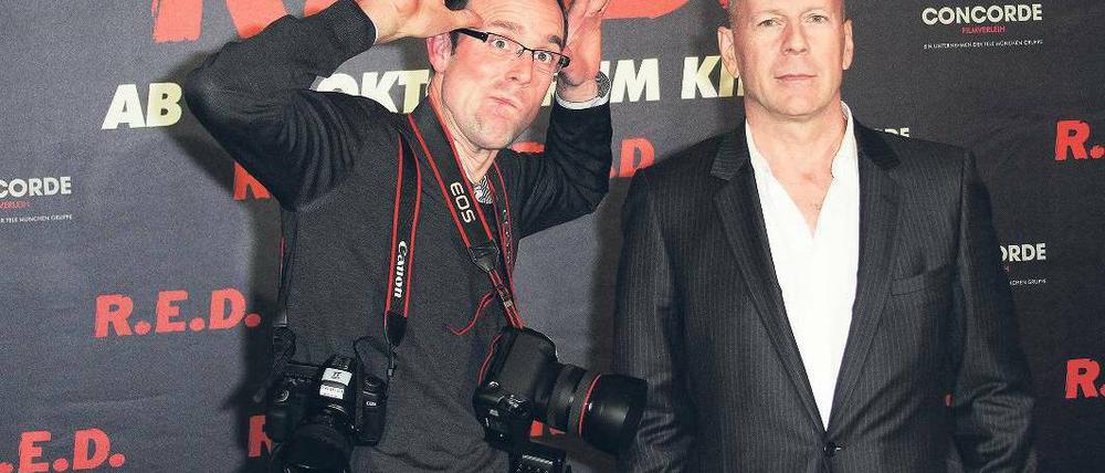 Fotofaxen. Genervt vom Blitzlichtgewitter holt Bruce Willis sich im Regent Hotel einen Fotografen an die Seite, der seinen Kollegen das Blitzen austreiben soll. Foto: Eventpress Radke