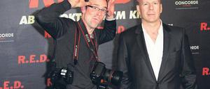 Fotofaxen. Genervt vom Blitzlichtgewitter holt Bruce Willis sich im Regent Hotel einen Fotografen an die Seite, der seinen Kollegen das Blitzen austreiben soll. Foto: Eventpress Radke
