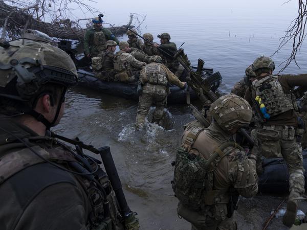 Ukrainische Soldaten steigen am Ufer des Flusses Dnipro an der Frontlinie nahe Cherson in ein Boot.