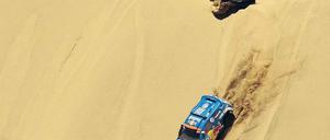 Dünenstürmer. Nasser Al-Attiyah aus Katar (unten) führt die Rallye Dakar knapp vor seinem spanischen VW-Teamkollegen Carlos Sainz an, Volkswagen wird den Wettbewerb wohl zum dritten Mal in Folge gewinnen. Foto: AFP