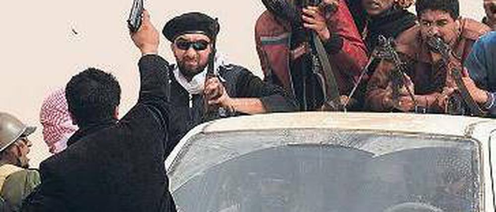 Rebellen im Osten Libyens marschieren in Richtung des Ölhafens Ras Lanuf. Sie schießen in die Luft und bereiten sich auf mögliche Kämpfe mit Gaddafi-treuen Truppen vor. Foto: Roberto Schmidt/AFP