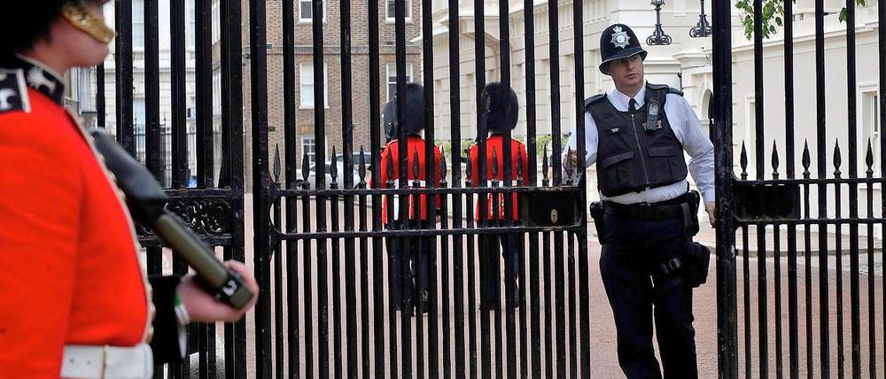 In London ist man auf große Ereignisse besser vorbereitet. Demnächst steht die Hochzeit des Prinzen an. Ein Polizist schließt die Tore vor dem St. James's Palace.