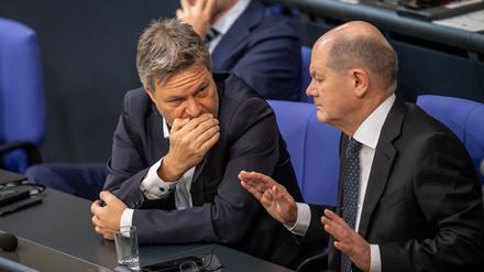 Bundeskanzler Olaf Scholz (SPD, r.), unterhält sich mit Wirtschaftsminister Robert Habeck (Bündnis 90/Die Grünen, M.).