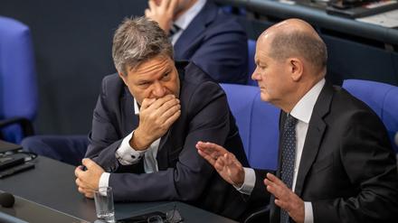 Bundeskanzler Olaf Scholz (SPD, r), unterhält sich mit Robert Habeck (Bündnis 90/Die Grünen, M), Bundesminister für Wirtschaft und Klimaschutz, neben Christian Lindner (FDP), Bundesminister der Finanzen, während der Debatte nach einer Regierungserklärung zur Haushaltslage im Bundestag. +++ dpa-Bildfunk +++