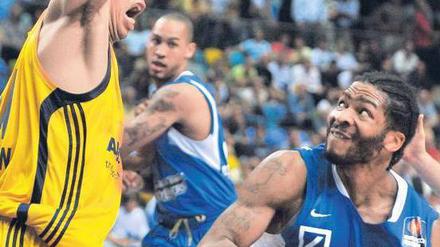 Die Angst des Angreifers vor Idbihi. Mit großem Respekt sieht Frankfurts Quantez Robertson (mit Ball) seiner Aufgabe gegen den Berliner Centerspieler entgegen. Foto: dpa