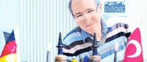 Dolmetscher zwischen den Kulturen. Kazim Erdogan wurde mehrfach ausgezeichnet. An seinem Arbeitsplatz in Neukölln wehen beide Landesfähnchen. 