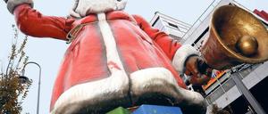 Einer von vielen. Sieben Meter misst der Plastikweihnachtsmann auf der Schlossstraße in Steglitz – Symbol für die Saison der Adventsmärkte, die ab heute eingeläutet ist. Jetzt locken die Budenstätten in der Hauptstadt wieder mit Glühwein, Bratwurstduft und Geschenken. Rund 90 Märkte sollen es dieses Jahr sein. Foto: dpa/Vogler