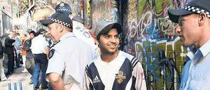 Unsichere Zukunft. Ein indischer Student spricht mit Polizisten in Australien. Dort gab es viele Überfälle auf Inder - die Zahl der Studierenden von Subkontinent fiel danach stark ab.