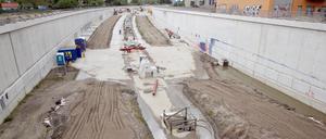 Bauarbeiter bringen auf der Baustelle der Erweiterung der A100 im Bezirk Neukölln den Untergrund für die Fahrbahnen auf. Die A100 soll in Richtung Friedrichshain ausgebaut werden, um den Berliner Osten besser an die Stadtautobahn anzubinden.