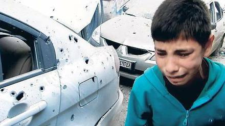 Gezeichnet. Ein Junge in den Straßen des Stadtteils Bab Tudmor in Homs, die Kampfspuren zeigen.
