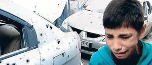 Gezeichnet. Ein Junge in den Straßen des Stadtteils Bab Tudmor in Homs, die Kampfspuren zeigen.