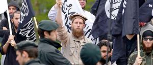 Polizisten stehen am 1. Mai in Solingen vor Salafisten, die gegen die rechtsgerichtete Bewegung Pro NRW protestieren. Pro NRW präsentierte zuvor bei einer Veranstaltung während der Feierlichkeiten zum 1. Mai umstrittene Islam-Karikaturen der Öffentlichkeit.