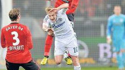 Bayer obenauf. Ömer Toprak fliegt, für Schalkes Lewis Holtby (in weiß) ist das zu hoch. Foto: dapd