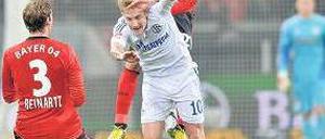 Bayer obenauf. Ömer Toprak fliegt, für Schalkes Lewis Holtby (in weiß) ist das zu hoch. Foto: dapd