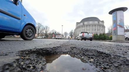 Ein Pkw fährt Mitte Dezember am Tempelhofer Damm an einem Schlagloch vorbei. Nach dem kürzlichen Wintereinbruch treten im gesamten Stadtgebiet verstärkt Straßenschäden auf, die durch Frost entstanden sind. 
