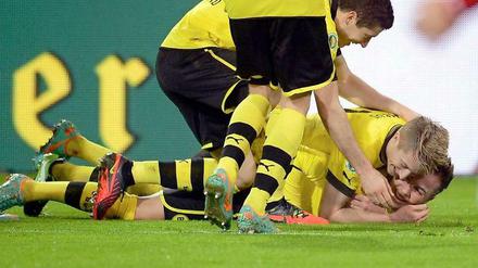 Am Boden erfreut: Dortmunds Robert Lewandowski (v. l. n. r), Marco Reus und Mario Götze jubeln über das 3:0 durch Götze.