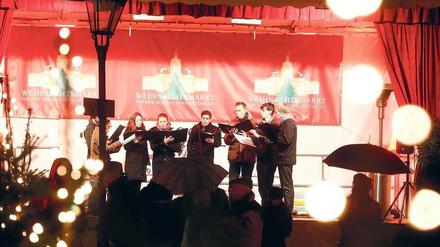 Schöne Stimmen. Auch auf Weihnachtsmärkten gibt es Konzerte. Vor dem Schloss Charlottenburg singt an jedem Abend ein Chor, hier der der Kantorei Mariendorf.