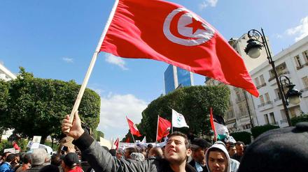 Aktivisten der Ennahda-Partei schwenken Tunesiens Flagge.