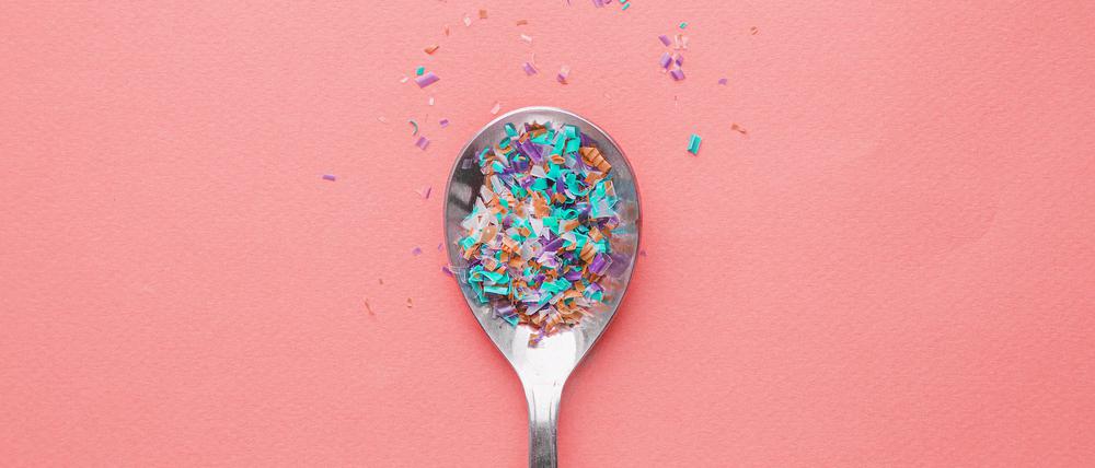 Environmental pollution and water microplastic. Micro plastic with spoon.