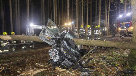 Feuerwehrleute stehen um ein Auto herum, das von einem Baumstamm durchbohrt im Wald liegt. Bei einem Verkehrsunfall in Österreich ist das Auto einer Lenkerin von einem Baum gepfählt worden. Die 27-jährige Frau überlebte jedoch und konnte sich selbstständig aus ihrem Fahrzeug befreien, wie die Polizei am Dienstag mitteilte. 