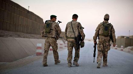 Drei Bundeswehrsoldaten patrouillieren durch das Feldlager in Kundus. Kurz vor dem Abzug der Bundeswehr aus der Stadt und der Übergabe des Camp an das afghanische Militär, wird das Lager besonders intensiv bewacht.