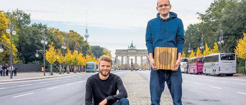 Zwei junge Männer mit Holzkästen vor dem Brandenburger Tor