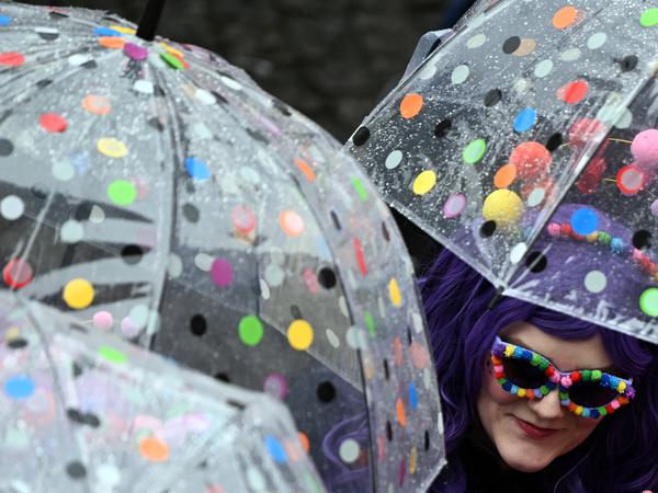 Einige Verkleidete stimmten die Kostüme mit ihrer Regenausrüstung ab: Hier passen Regenschirm und Sonnenbrille bestens zusammen. Bleibt zu hoffen, dass auch die Sonnenbrille noch ihren Zweck erfüllen wird.