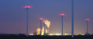 Der Schornstein und die Kühltürme des Braunkohlekraftwerks Schkopau dampfen hinter einem Windpark. Die kriegerischen Auseinandersetzungen lassen in Deutschland die Diskussion um den Ausstieg aus der Braunkohle und den Ausbau der Erneuerbaren Energien wieder aufleben. 