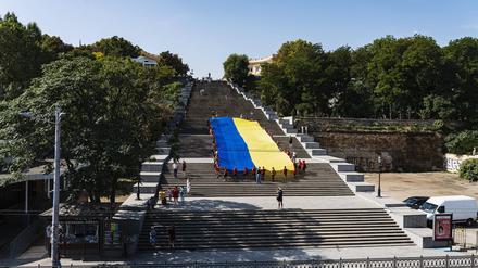 Auf der Potemkinschen Treppe in Odessa tragen Kinder die Ukrainische Flagge die Treppe hinauf.