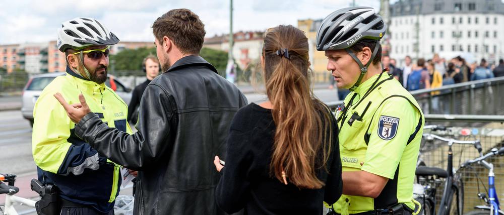 Polizisten der Fahrradstaffel kontrollieren auf der Warschauer Brücke.