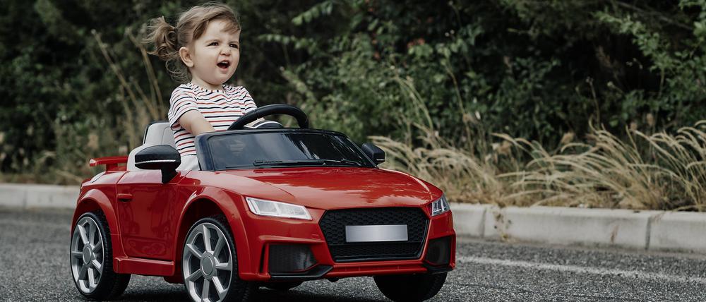A girl riding a toy car