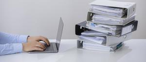 Symbolfoto zum Thema Digitalisierung in der Verwaltung . Ein Computer liegt neben einem Haufen Aktenordner. Berlin, 29.05.2019. Berlin Deutschland *** Symbol photo on the subject of digitisation in administration A computer lies next to a pile of files Berlin, 29 05 2019 Berlin Germany PUBLICATIONxINxGERxSUIxAUTxONLY Copyright: xThomasxTrutschel/photothek.netx  