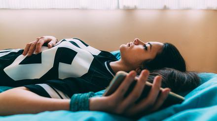 Young woman feeling worried after checking COVID-19 symptoms online and staying home for safety