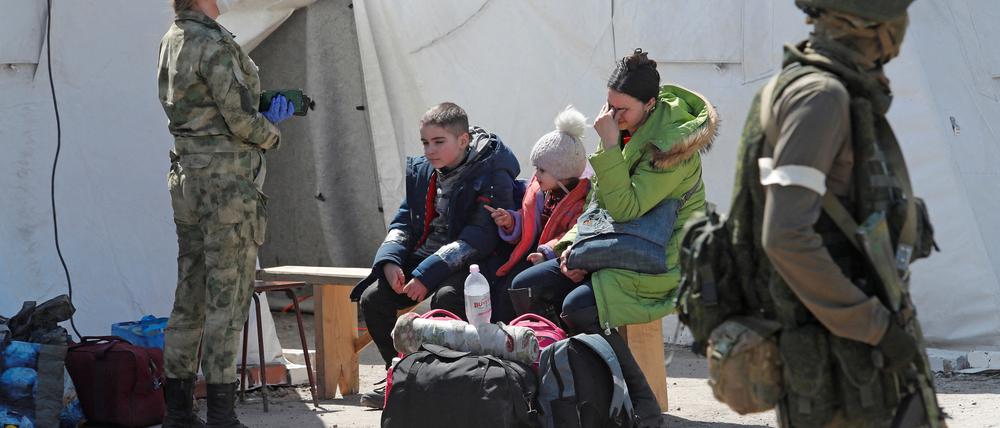 Eine aus dem Stahlwerk Asowstal evakuierte Frau sitzt mit ihren Kindern im Lager Bezimenne.