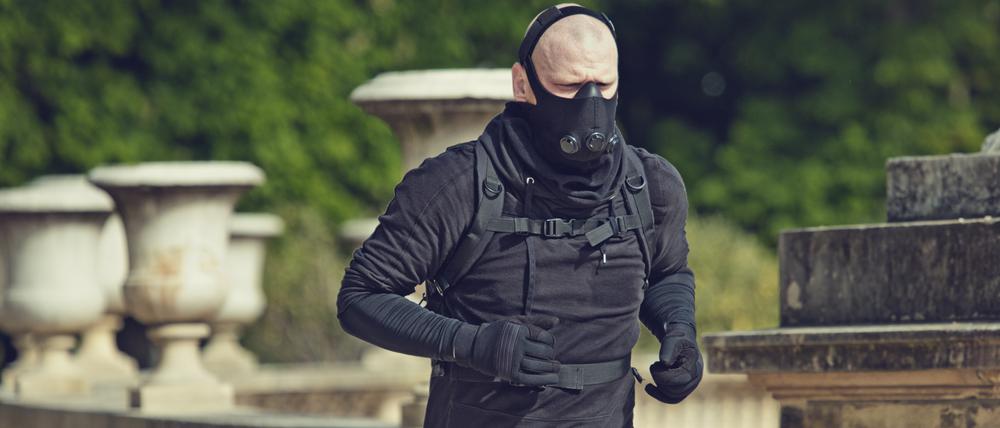 Ein Mann joggt mit Atemschutzmaske in einem Pariser Park.