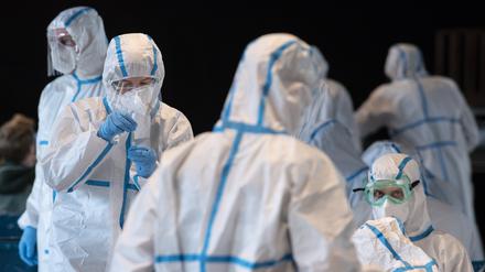 Mitarbeiter in einem Mainzer Corona-Testzentrum tragen Schutzanzüge.