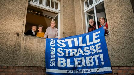 Alle ehemaligen Hausbesetzer:innen, halten am Fenster der «Begegnungsstätte für Jung und Alt» in der Stille Straße 10 in Berlin-Pankow ein altes Protestbanner. 