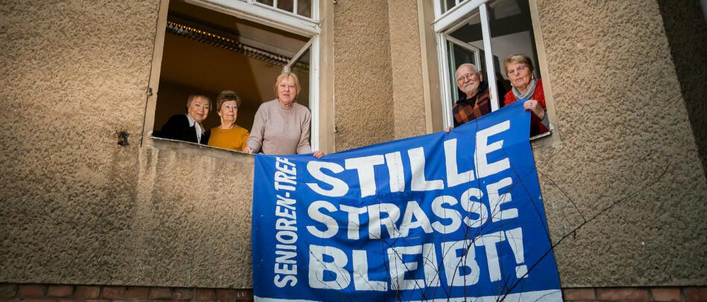 Alle ehemaligen Hausbesetzer:innen, halten am Fenster der «Begegnungsstätte für Jung und Alt» in der Stille Straße 10 in Berlin-Pankow ein altes Protestbanner. 