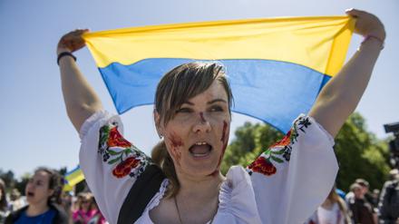 Die Solidarität mit der Ukraine ist riesig in Polen.  Eine Demonstrantin hält eine ukrainische Flagge hoch. 