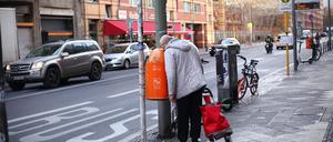 Ein Flaschensammler blickt am 18.12.2019 in einen Mülleimer auf der Kochstraße. Foto: Wolfram Steinberg/dpa