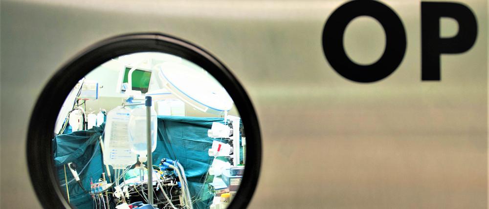 Blick durch ein Fenster in einen Operationssaal.