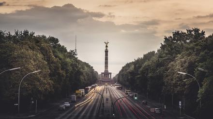Morgenrot hinter der Straße des 17. Juni mit Siegessäule und Fernsehturm in Berlin.