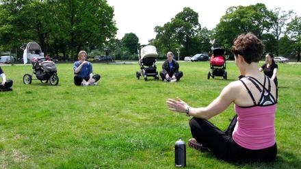 Junge Mütter beim Beckenbodentraining im Park. 