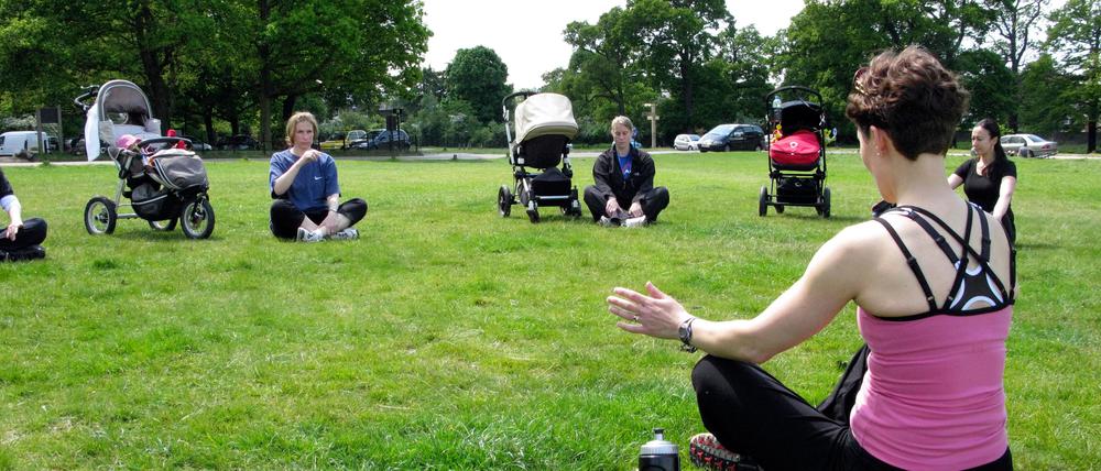 Junge Mütter beim Beckenbodentraining im Park. 