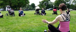 Junge Mütter beim Beckenbodentraining im Park. 